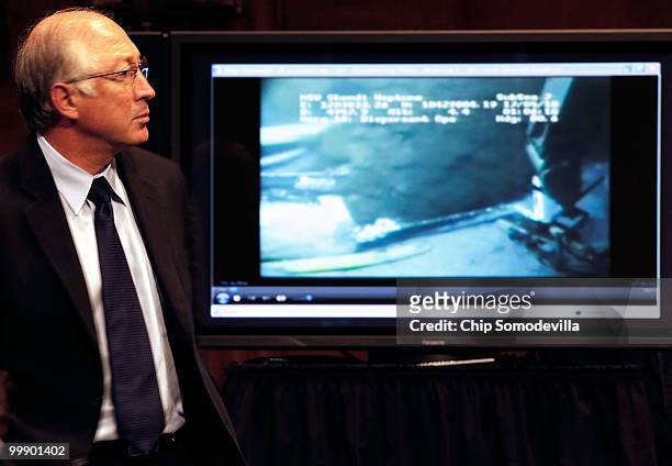 Secretary of the Interior Ken Salazar looks closely at a video of the broken well head at the bottom of the Gulf of Mexico while testifying before...