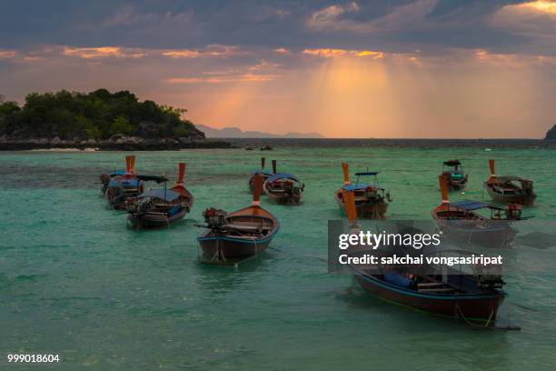 scenic view of longtail boats on the beach against sky during sunrise, koh lipe, thailand - longtail boat stock pictures, royalty-free photos & images