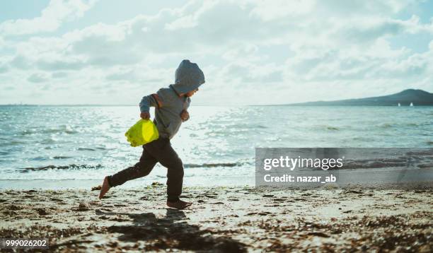 que se divierte corriendo en la playa en invierno. - nazar fotografías e imágenes de stock