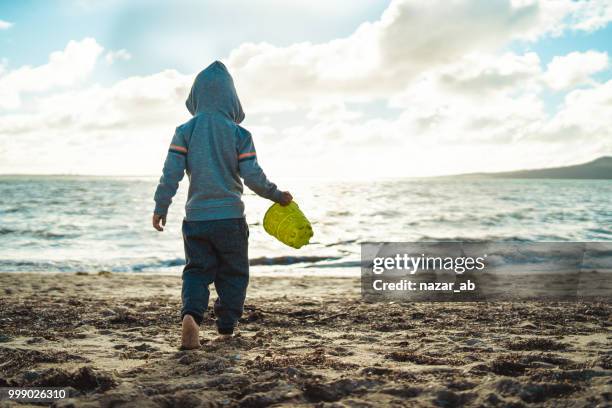 its fun playing at beach in winter. - hauraki gulf islands stock pictures, royalty-free photos & images