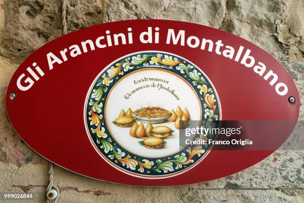 Banner showing Sicilian arancini for sale is seen close to the Montalbano's house, on June 04, 2018 in Punta Secca, Ragusa, Italy. Inspector Salvo...