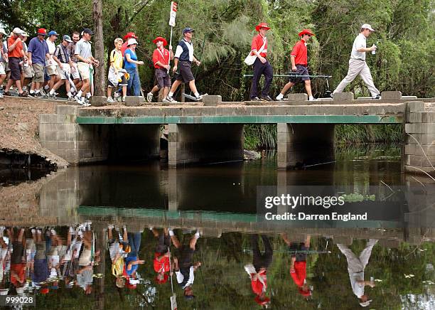 Scott Laycock of Australia crosses a bridge followed by the gallery during the final round of the Holden Australian Open Golf Tournament held at The...
