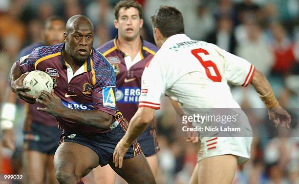 Wendell Sailor of the Broncos steps Trent Barrett of the Dragons during the first semi final NRL match between the St George Illawarra Dragons and...