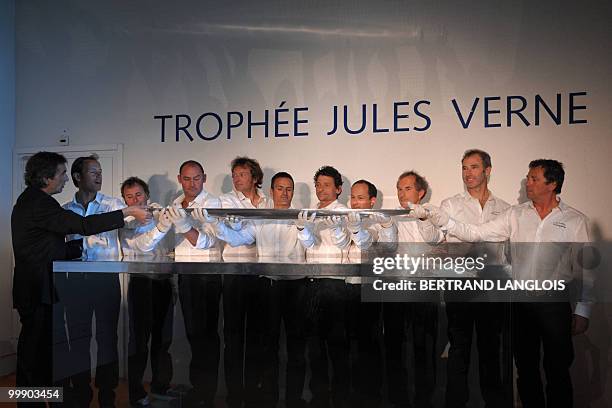 French skipper Franck Cammas and his teammates pose behind the Jules Verne Trophy, on May 18, 2010 during the award ceremony held at the National...