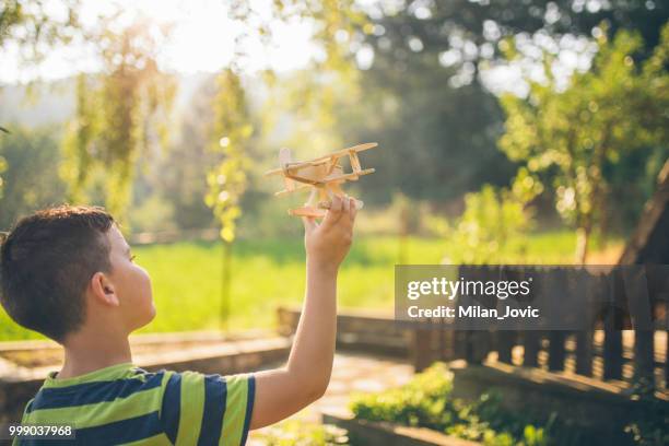 boy playing with toy airplane - jovic stock pictures, royalty-free photos & images