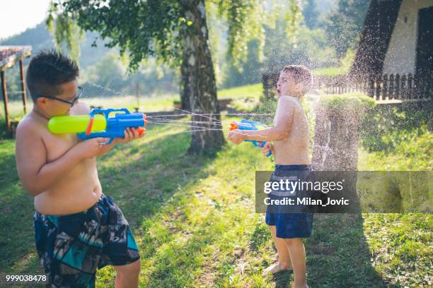 little boys playing with water guns in summer - jovic stock pictures, royalty-free photos & images