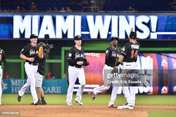 Cameron Maybin of the Miami Marlins high fives Martin Prado after defeating the Philadelphia Phillies at Marlins Park on July 14, 2018 in Miami,...