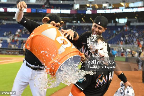 Miguel Rojas of the Miami Marlins and Yadiel Rivera attempt to pour water on Martin Prado after defeating the Philadelphia Phillies at Marlins Park...