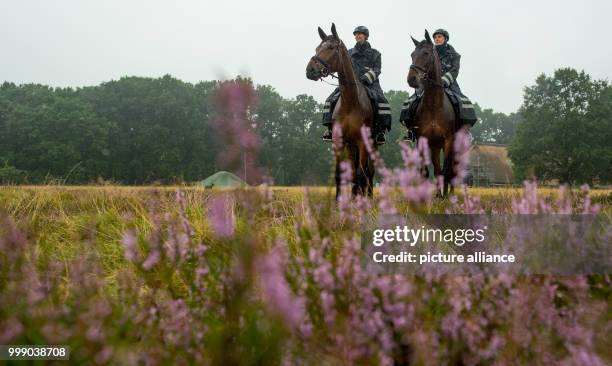 Police Commissioners Konstanze Brinckmann on her horse Karl and Sonja Bosse on her horse Geronimo riding through the heath landscape in the...