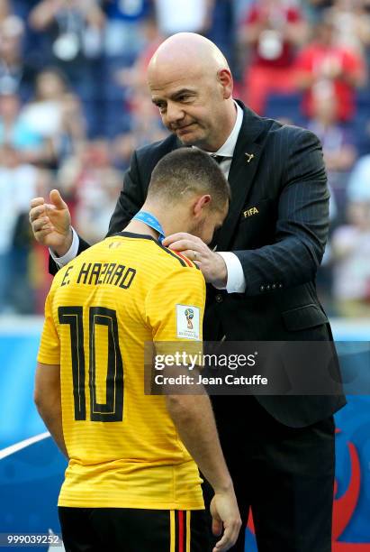 President Gianni Infantino gives a medal to Eden Hazard of Belgium during the medal ceremony for 3rd place following the 2018 FIFA World Cup Russia...