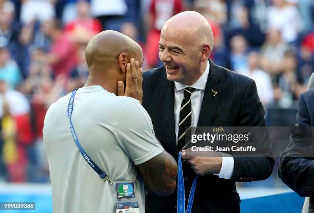 President Gianni Infantino gives a medal to assistant coach of Belgium Thierry Henry during the medal ceremony for 3rd place following the 2018 FIFA...