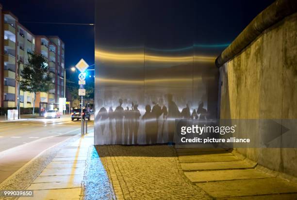 Dpatop - People passing by the "Berlin Wall Memorial" on the Bernauer Strasse being reflected on by a surface in Berlin, Germany, 11 August 2017....