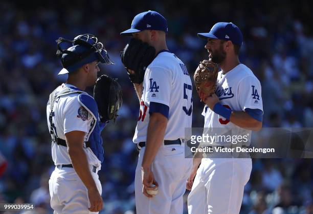 Catcher Austin Barnes, pitcher Alex Wood and shortstop Chris Taylor of the Los Angeles Dodgers confer on the mound in the second inning during the...