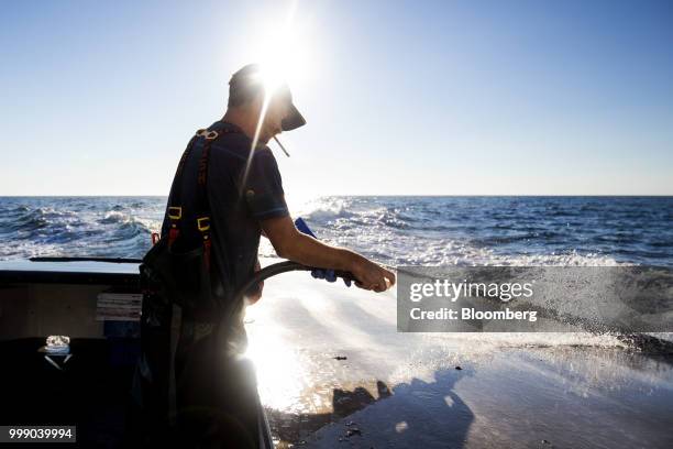 Fisherman hoses down a boat off the coast of Plymouth, Massachusetts, U.S., on Tuesday, July 10, 2018. The proposed tariffs between the U.S. And the...