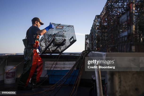 Fisherman moves a steel lobster trap on a boat off the coast of Plymouth, Massachusetts, U.S., on Tuesday, July 10, 2018. The proposed...