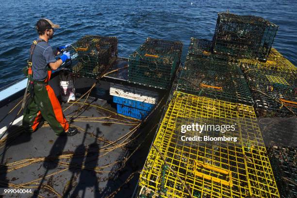 Fisherman moves a steel lobster trap on a boat off the coast of Plymouth, Massachusetts, U.S., on Tuesday, July 10, 2018. The proposed...