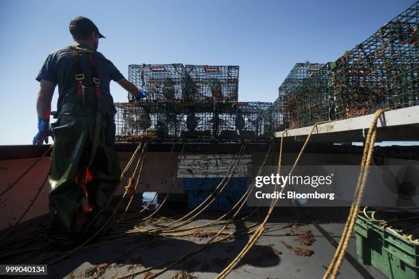 Fisherman moves a steel lobster trap on a boat off the coast of Plymouth, Massachusetts, U.S., on Tuesday, July 10, 2018. The proposed...