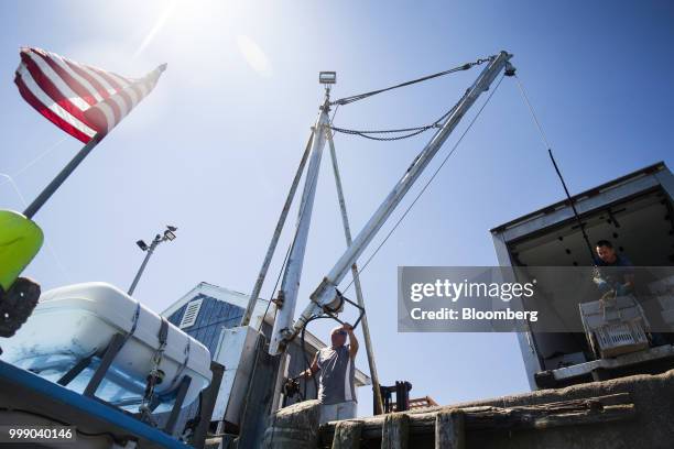 Fisherman moves containers filled with lobster on to a truck in Plymouth, Massachusetts, U.S., on Tuesday, July 10, 2018. The proposed...