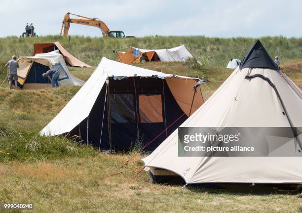 Parts of a digger can be seen in the background of the camp site on the East Frisian Island Spiekeroog, Germany, 11 July 2017. Directly on the beach...