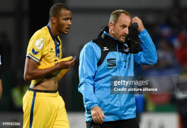 Braunschweig's Louis Samson and manager Torsten Lieberknecht leave the field at the end of the German Soccer Association Cup first round match...