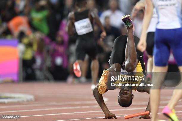 Jamaican athlete Usain Bolt tumbles head over heels after suffering an injury while competing in the men's 4 x 100 metre relay race at the IAAF World...