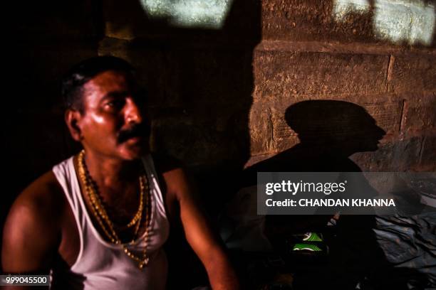 This photo taken on June 2, 2018 shows Bahadur Choudhary a fourth-generation caretaker of Varanasi's ancient cremation grounds, sitting on an...