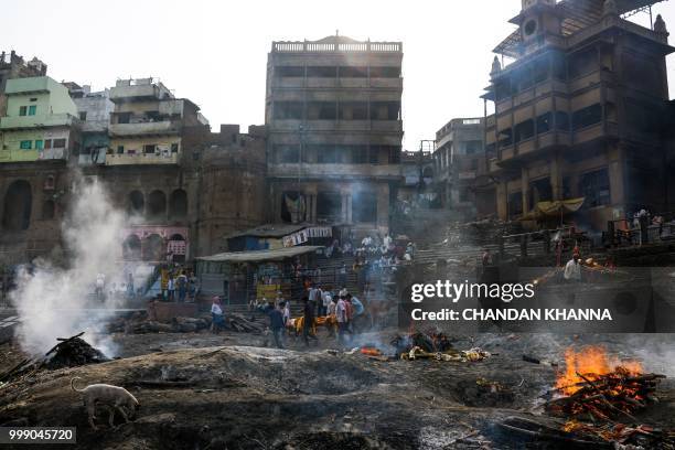 This photo taken on June 2, 2018 shows funeral pyres burning at the Manikarnika ghat in the old quarters of Varanasi. - The Doms are a small...