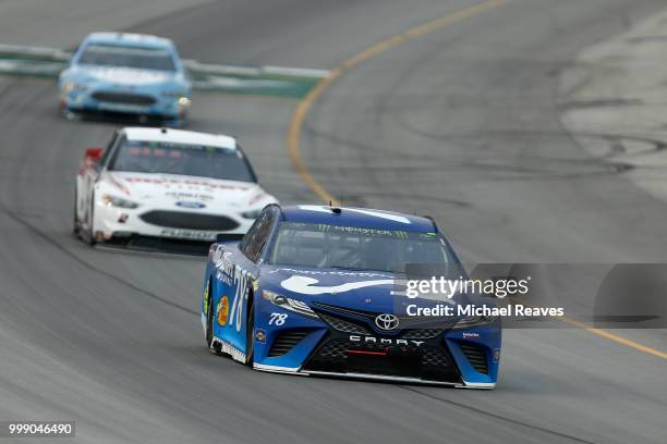 Martin Truex Jr., driver of the Auto-Owners Insurance Toyota, leads a pack of cars during the Monster Energy NASCAR Cup Series Quaker State 400...