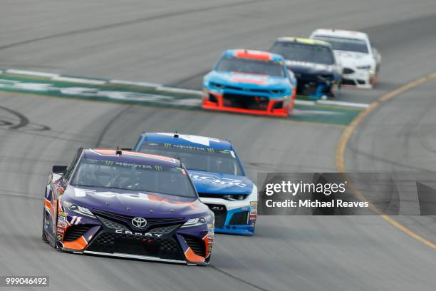 Denny Hamlin, driver of the FedEx Office Toyota, leads a pack of cars during the Monster Energy NASCAR Cup Series Quaker State 400 presented by...