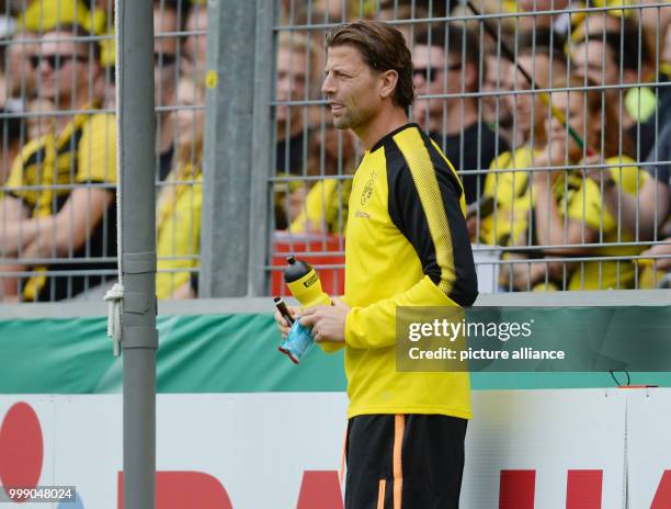 Dortmund's substitute goalkeeper Roman Weidenfeller brings his teammate Dennis Klose a gel and an electrolyte drink to ease the latter's cramps...