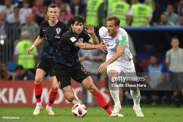 Harry Kane of England and Vedran Corluka of Croatia compete for the ball during the 2018 FIFA World Cup Russia Semi Final match between England and...