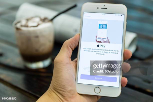 Man holds a smart phone with Apple Pay application is displayed on July 13 2018 in Hong Kong, Hong Kong.