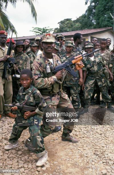 Le chef rebelle Prince Johnson, leader de l'Independent National Patriotic Front of Liberia, à la base Caldwell entouré notamment d'un enfant armé en...