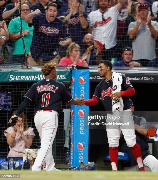 Jose Ramirez of the Cleveland Indians is congratulated by teammate Francisco Lindor as he returns to the dugout after scoring against the New York...