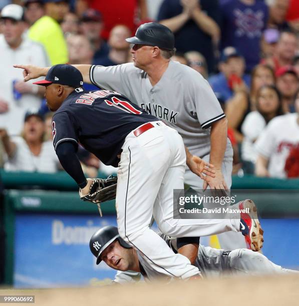 Jose Ramirez of the Cleveland Indians watches the ball go out of play as Austin Romine of the New York Yankees slides into third base in the seventh...