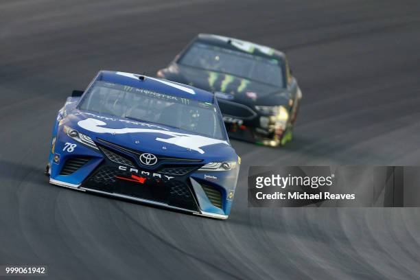 Martin Truex Jr., driver of the Auto-Owners Insurance Toyota, leads Kurt Busch, driver of the Monster Energy/Haas Automation Ford, during the Monster...