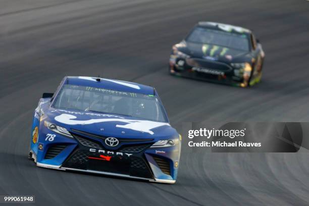 Martin Truex Jr., driver of the Auto-Owners Insurance Toyota, leads Kurt Busch, driver of the Monster Energy/Haas Automation Ford, during the Monster...