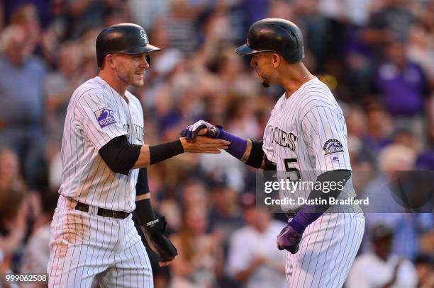 Trevor Story and Carlos Gonzalez of the Colorado Rockies celebrate after scoring on a 2-run homerun by Gonzalez in the second inning of a game...