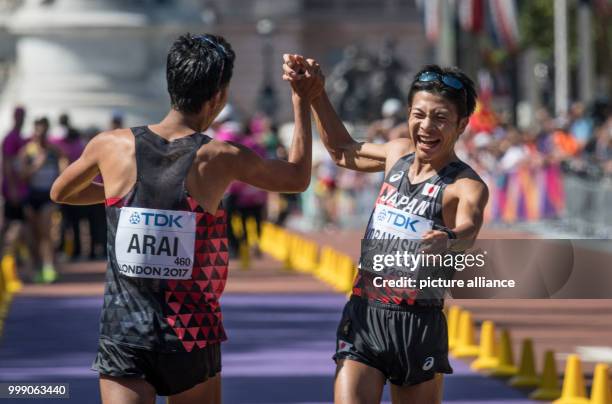 Japanese athletes Hirooki Arai and Kai Kobayashi celebrate after finishing the 50 kilometre marathon in second and third place at the IAAF London...