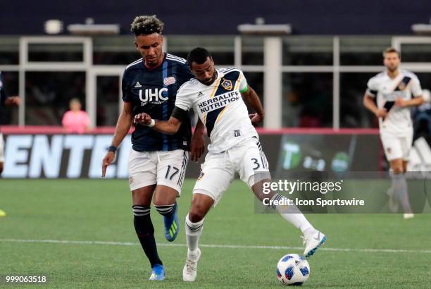 Los Angeles Galaxy defender Ashley Cole muscles New England Revolution forward Juan Agudelo off the ball during a match between the New England...