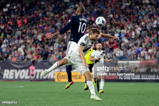 New England Revolution midfielder Teal Bunbury and Los Angeles Galaxy defender Jorgen Skjelvik battle in the air during a match between the New...