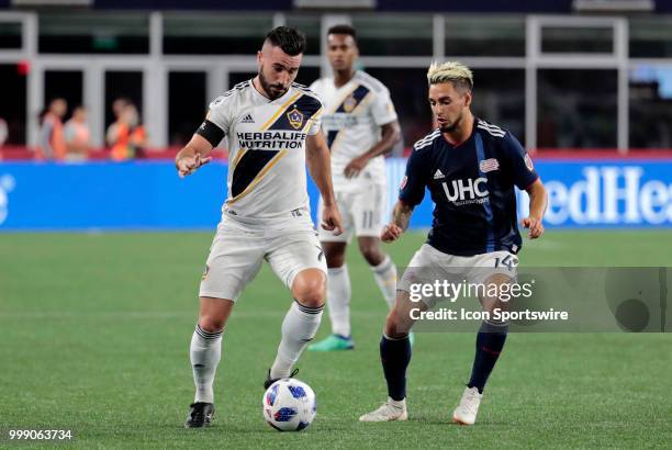 Los Angeles Galaxy midfielder Romain Alessandrini watched by New England Revolution midfielder Diego Fagundez during a match between the New England...