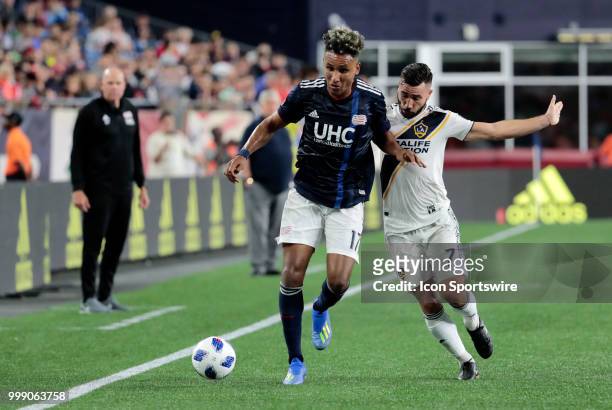 New England Revolution forward Juan Agudelo edges off Los Angeles Galaxy midfielder Romain Alessandrini during a match between the New England...