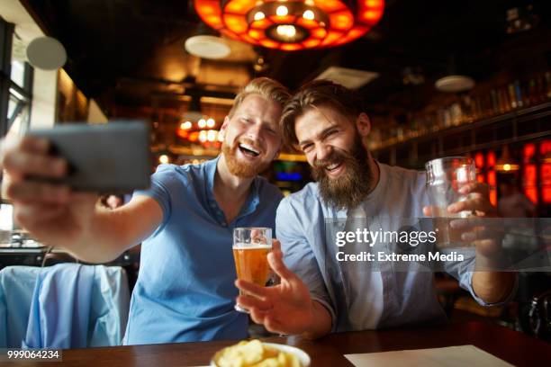 friends in the pub taking a selfie image while drinking beer - substance abuse programs stock pictures, royalty-free photos & images