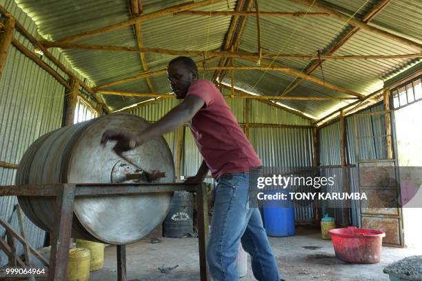 An employee churns fish pelts in tanning compounds using a mechanical drum on June 11 at the Alisam Product Development, a mini tannery owned by...