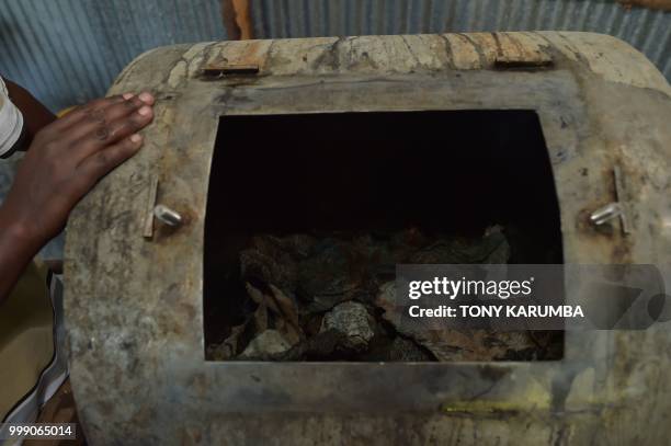 An employee prepares to churn fish pelts in tanning compounds using a mechanical drum on June 11 at the Alisam Product Development, a mini tannery...