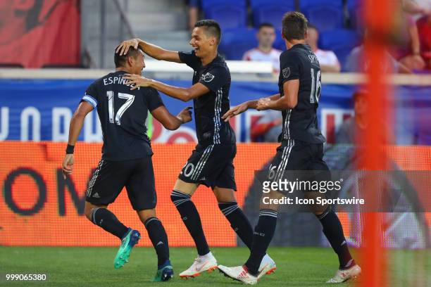 Sporting Kansas City midfielder Roger Espinoza celebrates with teammates after scoring during the second half of the Major League Soccer game between...
