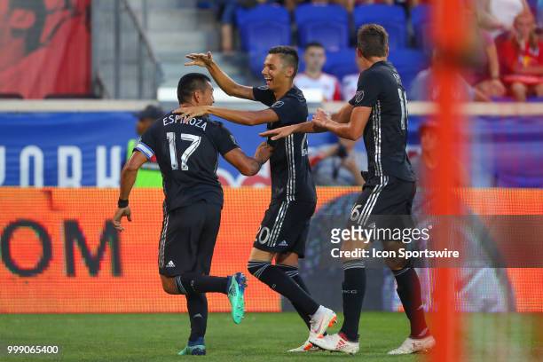 Sporting Kansas City midfielder Roger Espinoza celebrates with teammates after scoring during the second half of the Major League Soccer game between...