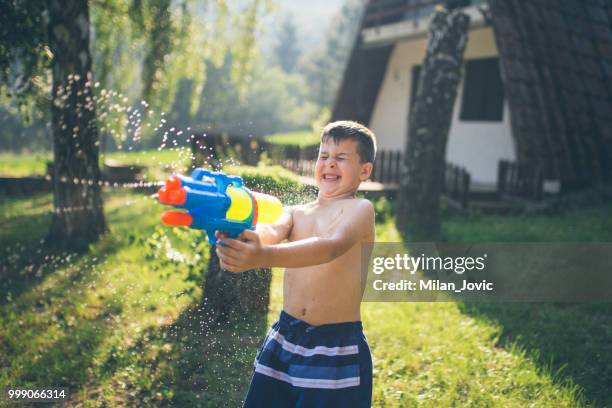 little boy splashing with water gun - jovic stock pictures, royalty-free photos & images