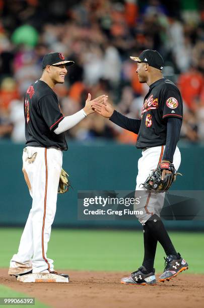 Manny Machado and Jonathan Schoop of the Baltimore Orioles celebrate after a 1-0 victory against the Texas Rangers at Oriole Park at Camden Yards on...